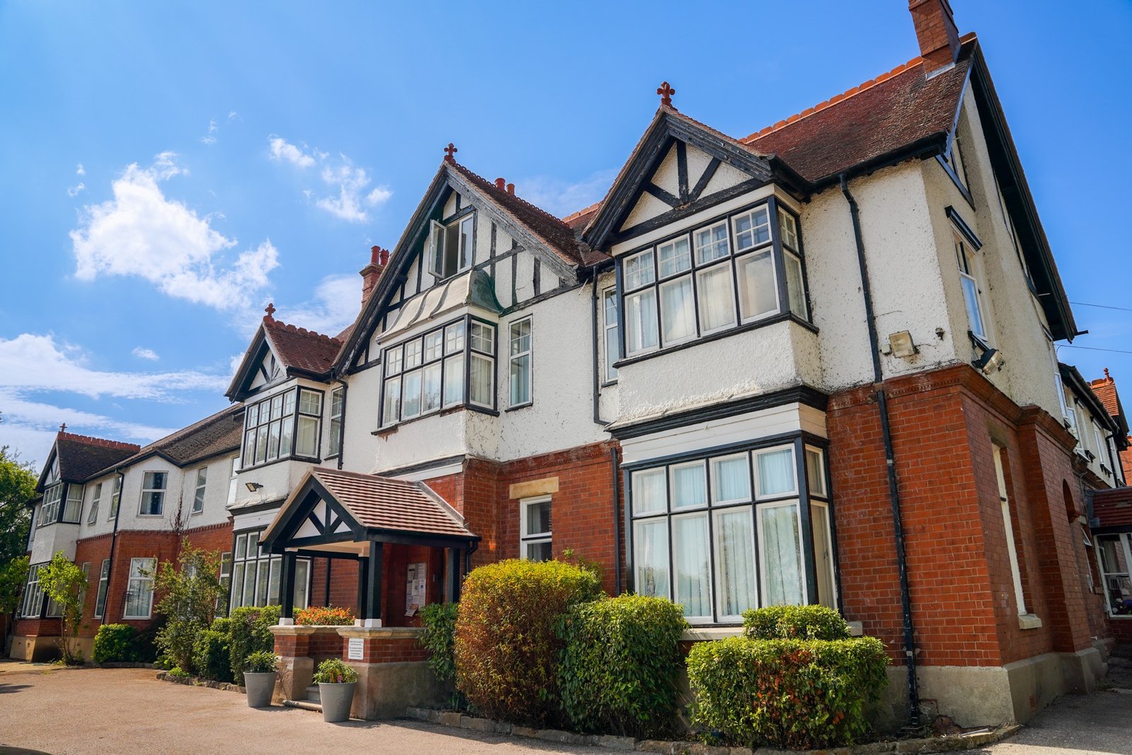 Close view of the home's Tudor-style gables and brickwork under a clear blue sky