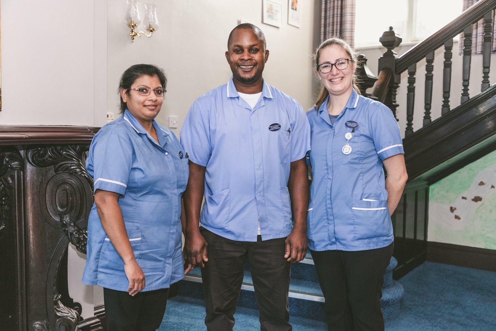 Three care home staff members smiling together